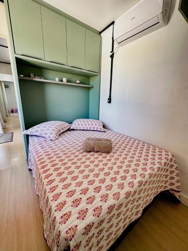 a bedroom with a bed with a red and white comforter at Container Bem-te-Vi! in Siderópolis