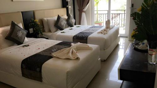 two beds in a hotel room with at Muine Sports Hotel in Mui Ne