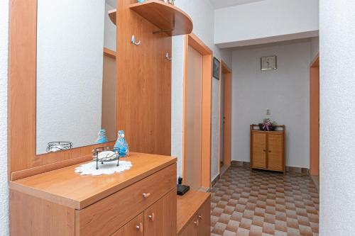ein Ankleidezimmer mit Spiegel und Holzkommode in der Unterkunft Apartments by the sea Tucepi, Makarska - 19857 in Tučepi