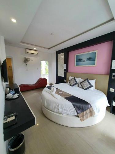 a bedroom with a large bed with a pink wall at Muine Sports Hotel in Mui Ne