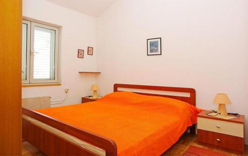 um quarto com uma cama com um cobertor laranja em Apartments by the sea Brna, Korcula - 20827 em Smokvica