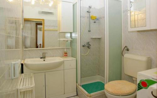 uma casa de banho com um WC com lavatório e um chuveiro em Apartments by the sea Brna, Korcula - 20827 em Smokvica
