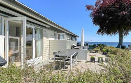a house with a table and chairs on a patio at Awesome Apartment In Allinge in Allinge