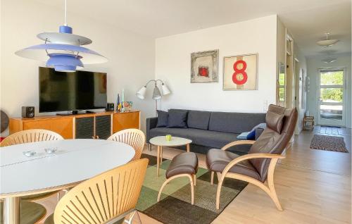 a living room with a couch and a table and chairs at Awesome Apartment In Allinge in Allinge