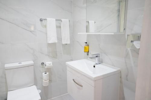 a white bathroom with a toilet and a sink at Best Western Buckingham Palace Rd in London