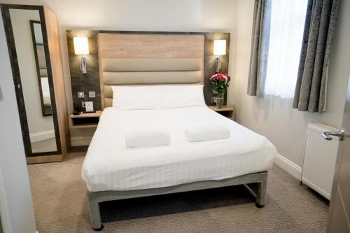 a bedroom with a white bed and a mirror at Best Western Buckingham Palace Rd in London