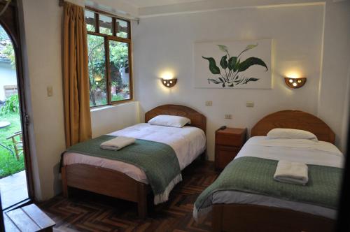 1 Schlafzimmer mit 2 Betten und einem Fenster in der Unterkunft Las Orquideas Ollantaytambo in Ollantaytambo