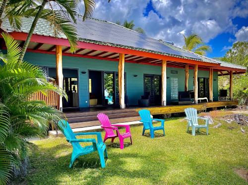 eine Gruppe von Stühlen, die vor einem Haus sitzen in der Unterkunft Turia's Beach Villa in Moorea