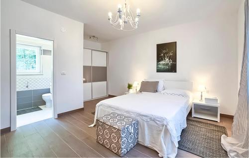 a white bedroom with a bed and a bathroom at Lovely Home In Snasici With Sauna in Mali Turini