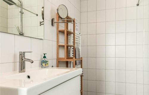 La salle de bains blanche est pourvue d'un lavabo et d'un miroir. dans l'établissement Maroma Mistral, à Kamperland