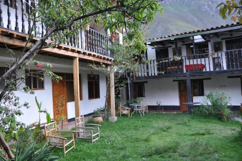 ein Haus mit Stühlen und Tischen im Hof in der Unterkunft Las Orquideas Ollantaytambo in Ollantaytambo