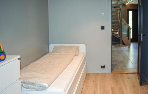 a white bed in a room with a hallway at Awesome Home In Brevik With Outdoor Swimming Pool in Bjønnes