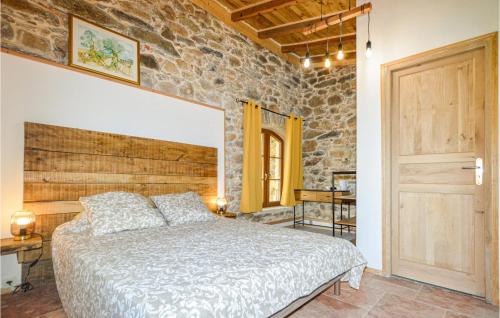 a bedroom with a bed and a stone wall at 4 Bedroom Beautiful Home In Feliceto in Feliceto