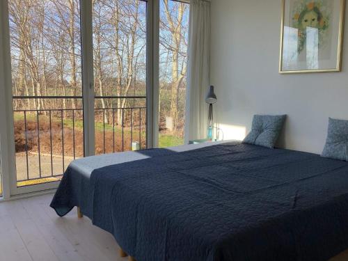 een slaapkamer met een bed en een groot raam bij Holiday home Thyholm XXVII in Thyholm