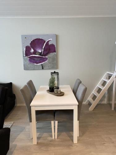 a dining room table with chairs and a purple flower at Helt ny rorbu på Slyngstad i Ålesund Kommune in Ålesund