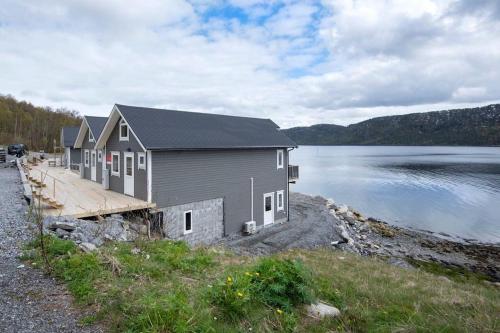 a house on the shore of a body of water at Helt ny rorbu på Slyngstad i Ålesund Kommune in Ålesund