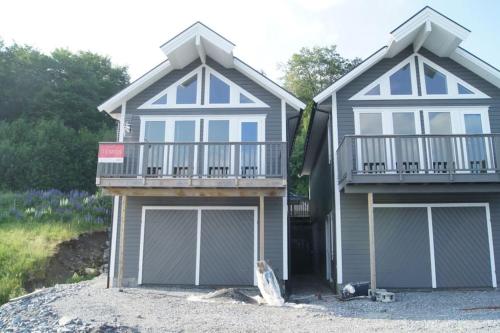 a house with two garage doors and a balcony at Helt ny rorbu på Slyngstad i Ålesund Kommune in Ålesund