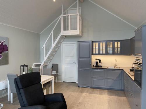 a kitchen with blue cabinets and a staircase at Helt ny rorbu på Slyngstad i Ålesund Kommune in Ålesund