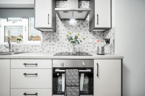 伯明罕的住宿－Modern home，厨房配有白色橱柜和水槽