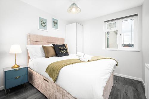 een witte slaapkamer met een groot bed en een raam bij Modern home in Birmingham