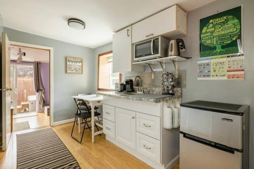 cocina con armarios blancos y encimera en Tiny House with private Hot Tub near Seattle en Shoreline
