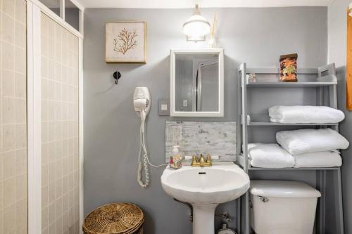 y baño con lavabo, aseo y toallas. en Tiny House with private Hot Tub near Seattle en Shoreline