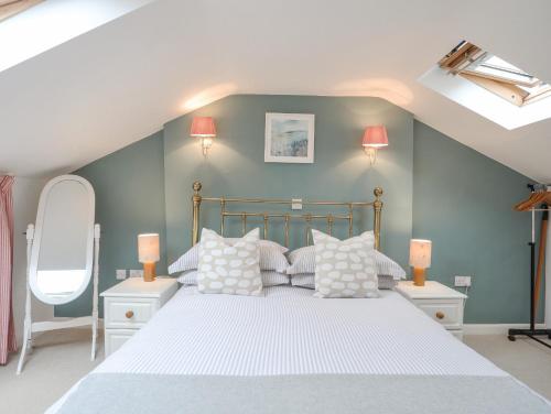 a bedroom with a bed with white sheets and pillows at Ty Hydref in Beaumaris
