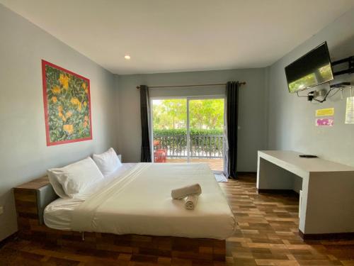 1 dormitorio con 1 cama, escritorio y ventana en Baan Ruay Suk Resort, Lopburi en Lop Buri