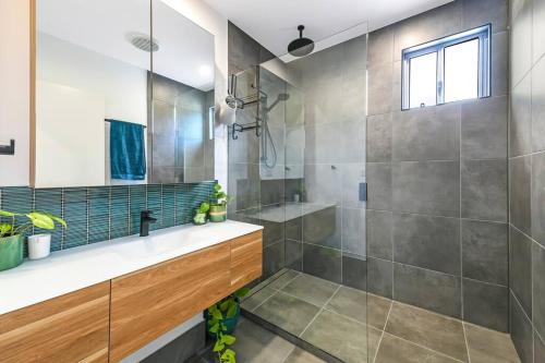 La salle de bains est pourvue d'une douche et d'un lavabo. dans l'établissement Beach House with spa among the trees Coolum Beach, à Coolum Beach