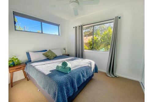 a bedroom with a green teddy bear sitting on a bed at Beach House with spa among the trees Coolum Beach in Coolum Beach