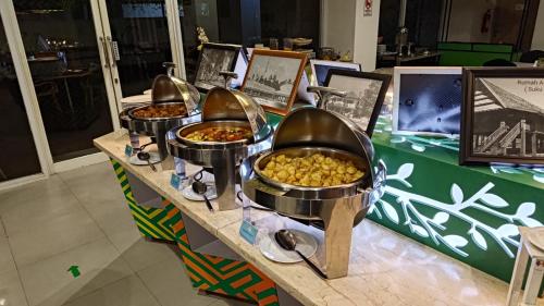 a buffet with three bowls of food on a table at KHAS Makassar Hotel in Makassar