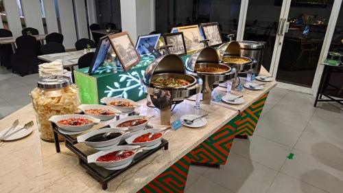 a table with many dishes of food on it at KHAS Makassar Hotel in Makassar