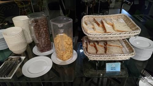 a table with bread and other food items on it at KHAS Makassar Hotel in Makassar