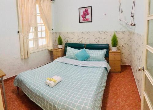 a bedroom with a bed with a blue comforter at City Pass Da Lat in Da Lat