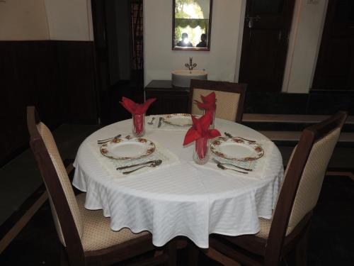 a table with a white table cloth and red napkins at Kunjpur Guest House in Allahābād