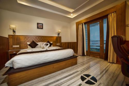 a bedroom with a large bed and a large window at Hotel Amil in Rājapālaiyam