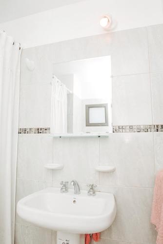 Baño blanco con lavabo y espejo en Departamento amplio con PILETA en GENERAL PAZ en Córdoba