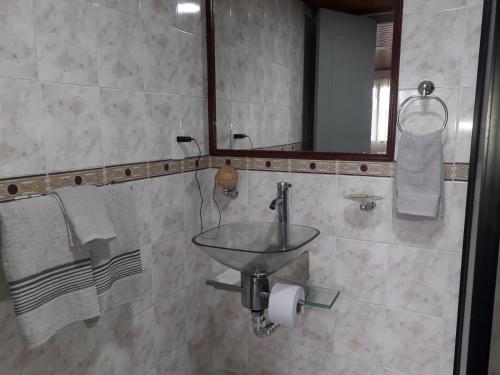 W łazience znajduje się umywalka, lustro i ręczniki. w obiekcie Casa rural o chalet w mieście Santa Rosa de Cabal