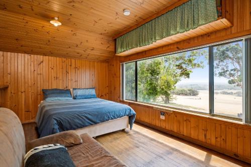1 dormitorio con cama y ventana grande en Augusta Sheoak Chalets, en Augusta
