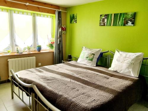 een slaapkamer met een bed met groene muren en ramen bij Gîte Bailleul, 4 pièces, 6 personnes - FR-1-510-176 in Bailleul