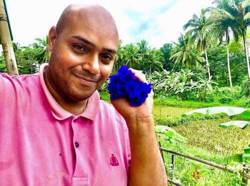 a man in a pink shirt holding a blue object at Sobral Rice Terraces View in Antihon