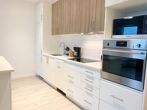 a kitchen with white cabinets and a stove top oven at Cozy 1BR Condo w/ Insuite LDRY, Gym & Free Parking in Waterloo