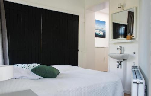 een slaapkamer met een wit bed en een wastafel bij 3 Bedroom Amazing Home In Arnemuiden in Arnemuiden