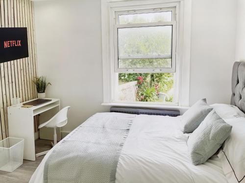a white bedroom with a bed and a window at Modern Room in Centrally Located Apartment - Room 4 in London