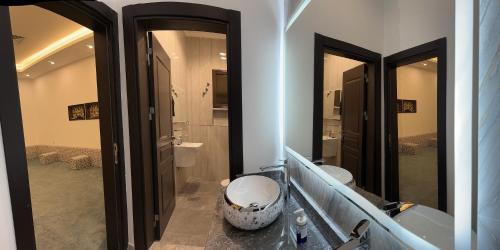 a bathroom with two mirrors and a sink and a toilet at منتجع اووه يامال البحري في الخيران OOh Yaa Mal in Al Khīrān