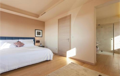 a bedroom with a white bed and a sliding door at Lovely Home In Vabriga With Kitchen in Vabriga