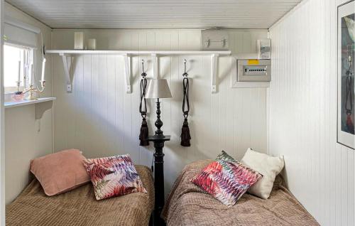 Cette petite chambre comprend deux lits et une lampe. dans l'établissement 1 Bedroom Beautiful Home In Falkenberg, à Falkenberg