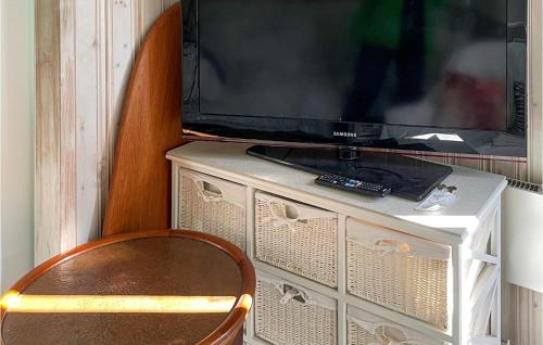 a television sitting on top of a dresser with a chair at 1 Bedroom Beautiful Home In Falkenberg in Falkenberg