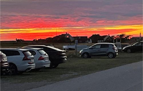 a group of cars parked in a parking lot at sunset at 1 Bedroom Beautiful Home In Falkenberg in Falkenberg