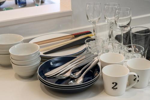 a table topped with plates and glasses and utensils at 最大12人築浅物件 南部を満喫したい方に1番のおすすめ宿 無料駐車場3台 サウスウィンドハウス in Inamine